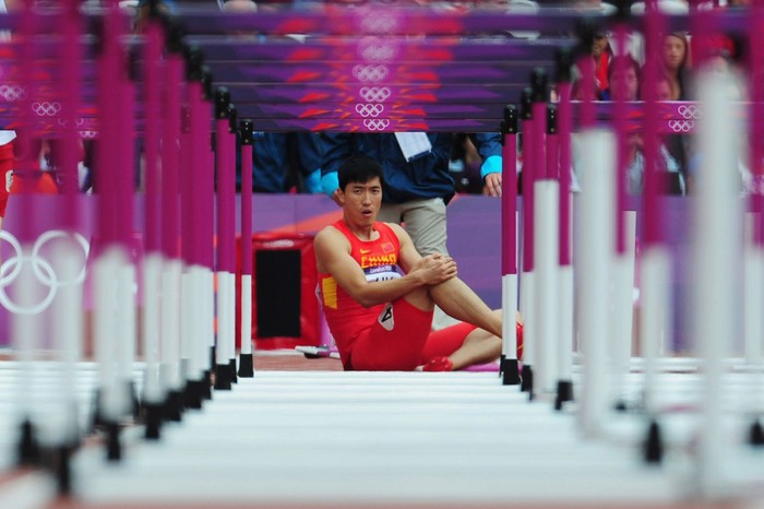 Lưu Trường của Trung Quốc ngồi bất lực sau khi bị chấn thương ở vòng loại chạy 110m vượt rào.